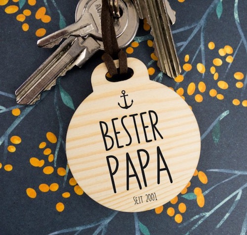 Runder Schlüsselanhänger aus Holz mit der Gravur eines kleinen Ankers und dem Schriftzug "Bester Papa seit Datum"